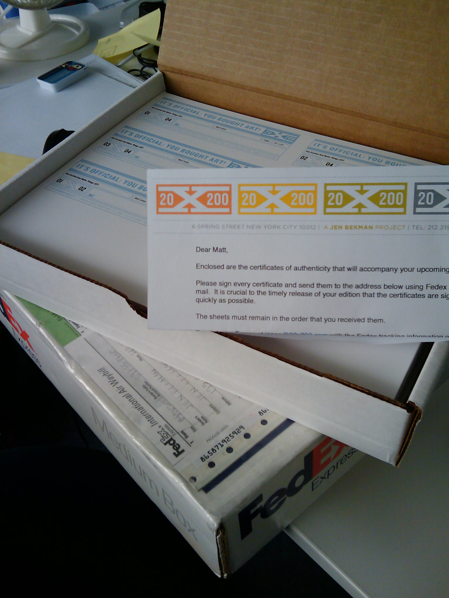A box of 20x200 certificates of authenticity for the Get Excited and Make Things print, with a covering letter from Jen Bekman's 20x200, waiting to be signed