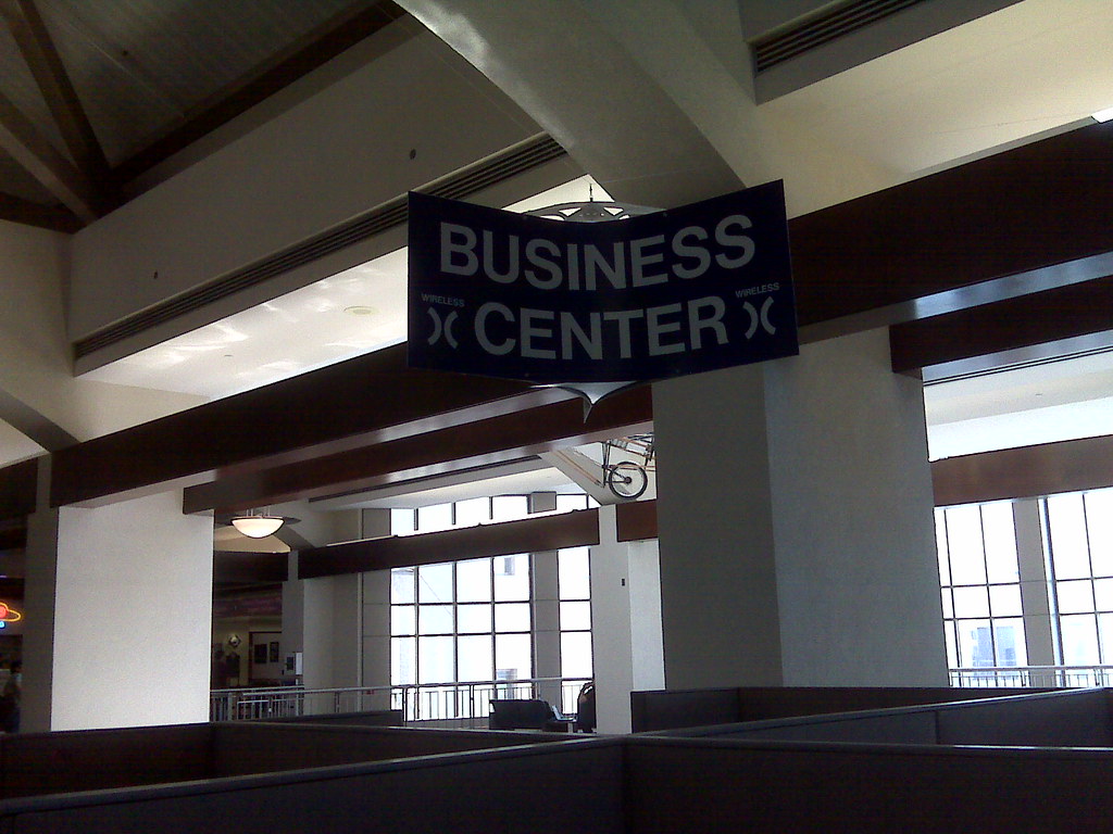 A hotel 'Business Center' sign using the warchalking open-node symbol either side of the word WIRELESS